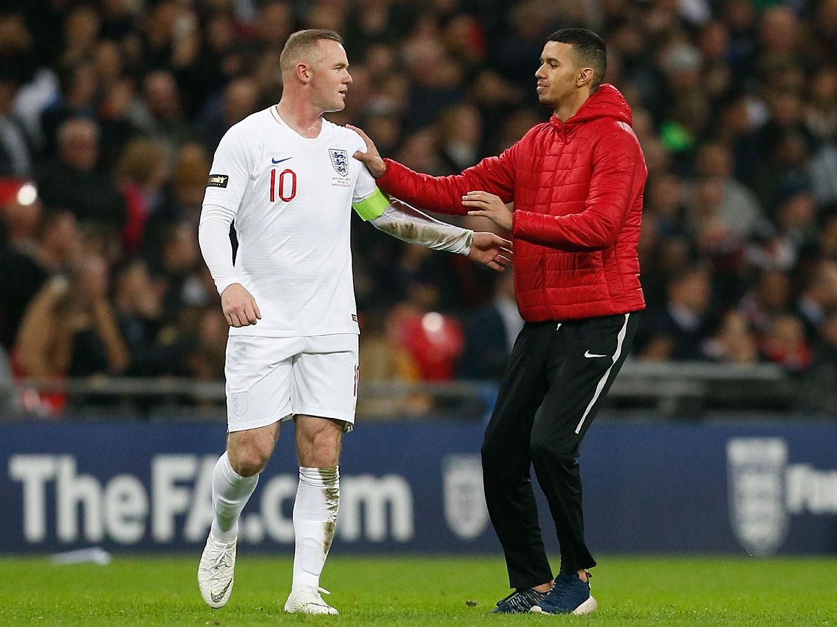 Rooneyt egy pályára rohanó szurkoló is köszöntötte a búcsúmérkőzésén (Fotó: AFP)