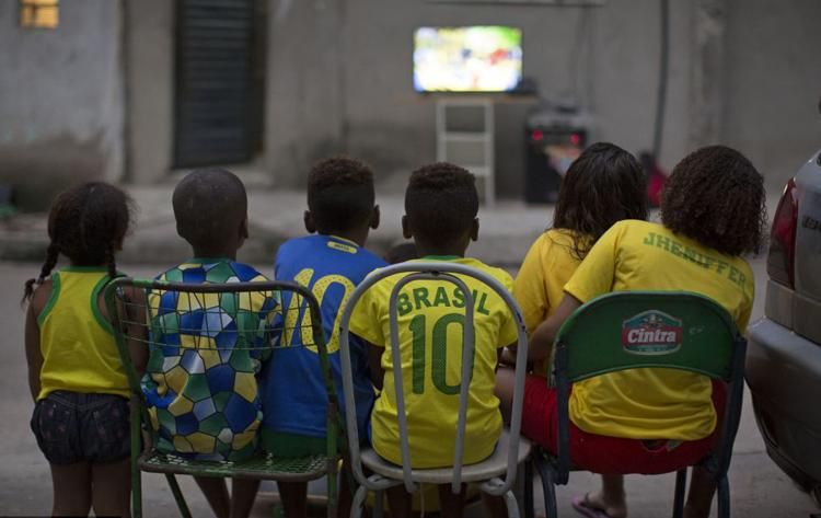 Gyerekek nézik a brazil–horvát meccset egy sikátorban, Rio de Janiero egyik nyomornegyedében