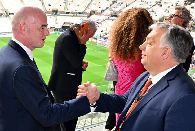 Gianni Infantino and Viktor Orbán shaking hands - in the background, Italian Ballon d'Or player Roberto Baggio on the phone