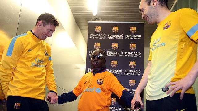 Lionel Messi az egyik, Andrés Iniesta a másik oldalon – Mamadou Lamine pedig középen (Fotó: foundation.fcbarcelona.com)