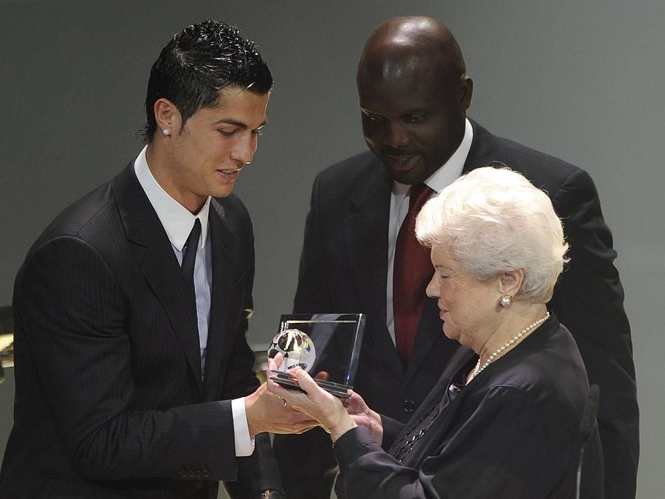 Cristiano Ronaldo Puskás Ferencnétől veszi át 2009-ben az első Puskás-díjat, a háttérben George Weah (Fotó: AFP)
