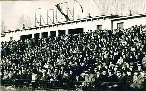 A KEAC-stadion Tápé felöli részén zsúfolt a lelátó, a tribün fölött már csak az üres  képkeret idézi, hogy korábban onnan figyelt a szigorú Sztálin, Rákosi és Lenin…