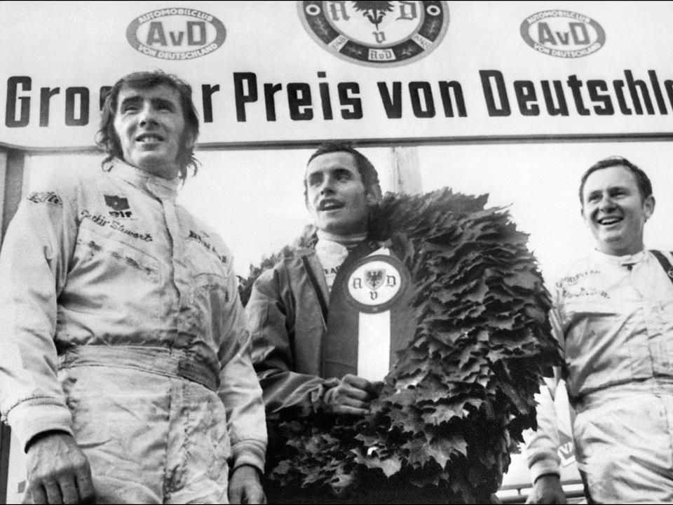 Balról Jackie Stewart, a győztesnek járó babérkoszorúval Jacky Ickx és Bruce McLaren az 1969-es Német Nagydíj után a Nürburgringen  (Fotó: AFP)