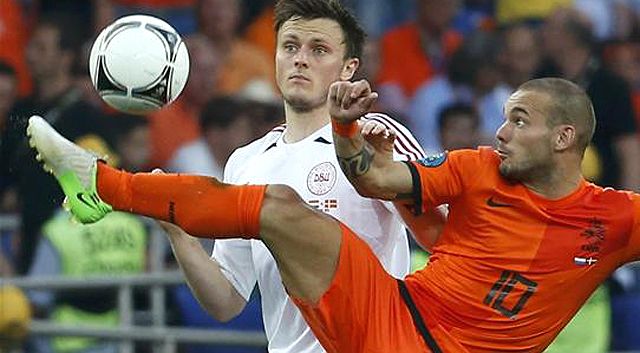 A holland Wesley Sneijder (jobbra) bűvöli a labdát és a dán William Kvistet