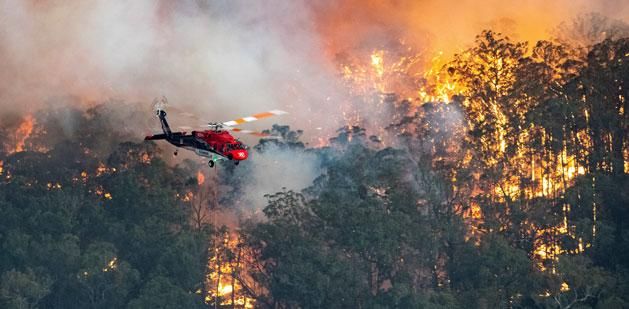 A tomboló tüzet helikopterről leöntött oltóanyaggal próbálják megfékezni (Fotó: AFP)