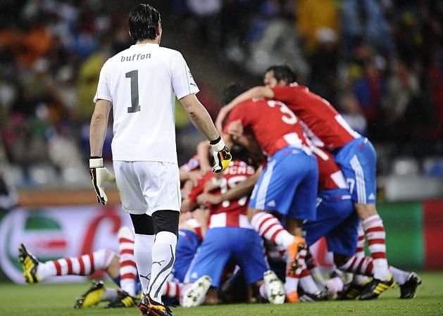 Gianluigi Buffon itt még a pályán, a háttérben góljukat ünneplő paraguayiak (Fotó: AFP)