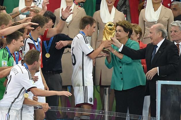 A 2014-es vb-trófea átadásánál az ünneplő németek csapatkapitánya, Philipp Lahm és a brazil államfő, Dilma Rousseff társaságában (Fotó: AFP)