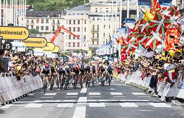 A Tour de France mezőnye baszk zászlók tengerében hajrázik – sok ember óriási munkája fekszik a körversenyben