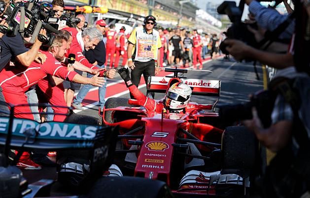 Maurizio Arrivabene csapatfőnök köszönti a bokszba érkező Vettelt