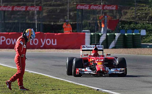Alonso korábban a pályán leállított Ferrari mellett (Fotó: Reuters)