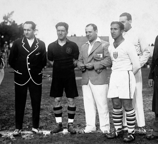 Pierre Braine belga és Thomas Florie (fehérben) amerikai csapatkapitány között a mérkőzés elegáns argentin játékvezetője, José Macías álldogál