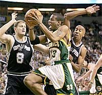 Bátraké a szerencse. Antonio Daniel (Seattle) pedig bátor ember, hiszen a Rasho Nesterovicm-Bruce Boven (San Antonio) kettős között is megpróbálkozik a pontszerzéssel (fotó: Reuters)