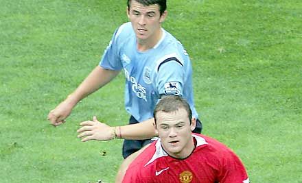 Barton (hátul) Rooney után a három meccs után még hibátlan Manchester Unitedet is elgáncsolta, így már csak két százszázalékos csapat van a mezônyben (Fotó: Getty Images)