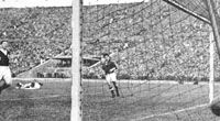 Az 1955. májusi, skótok elleni mérkôzésen Fenyvesi Máté (a kép közepén) ragyogó cselsorozat után &#8211; a kapus mögötte a földön, a védô lemaradva &#8211; a magyar csapat harmadik gólját szerzi. A Népstadion lelátóin ekkor százezer szurkoló ünnepelt