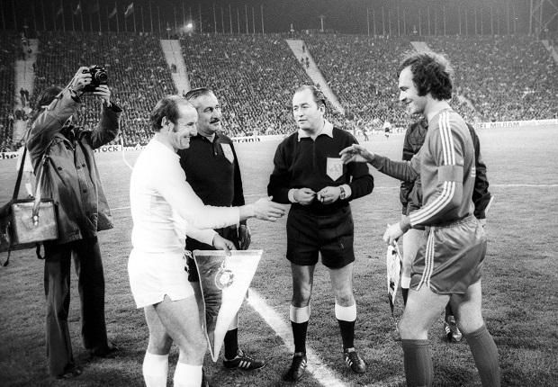 1974. április 24.: Bene Ferenc, az Újpesti Dózsa támadója és Franz Beckenbauer, a Bayern München középhátvédje készül kezet fogni a kezdőkörben a két csapat BEK-elődöntőjének müncheni visszavágója előtt a szovjet Pavel Kazakov játékvezető oldalán. A mérkőzést a továbbjutó bajorok nyerték 3–0-ra (Fotó: Imago Images)