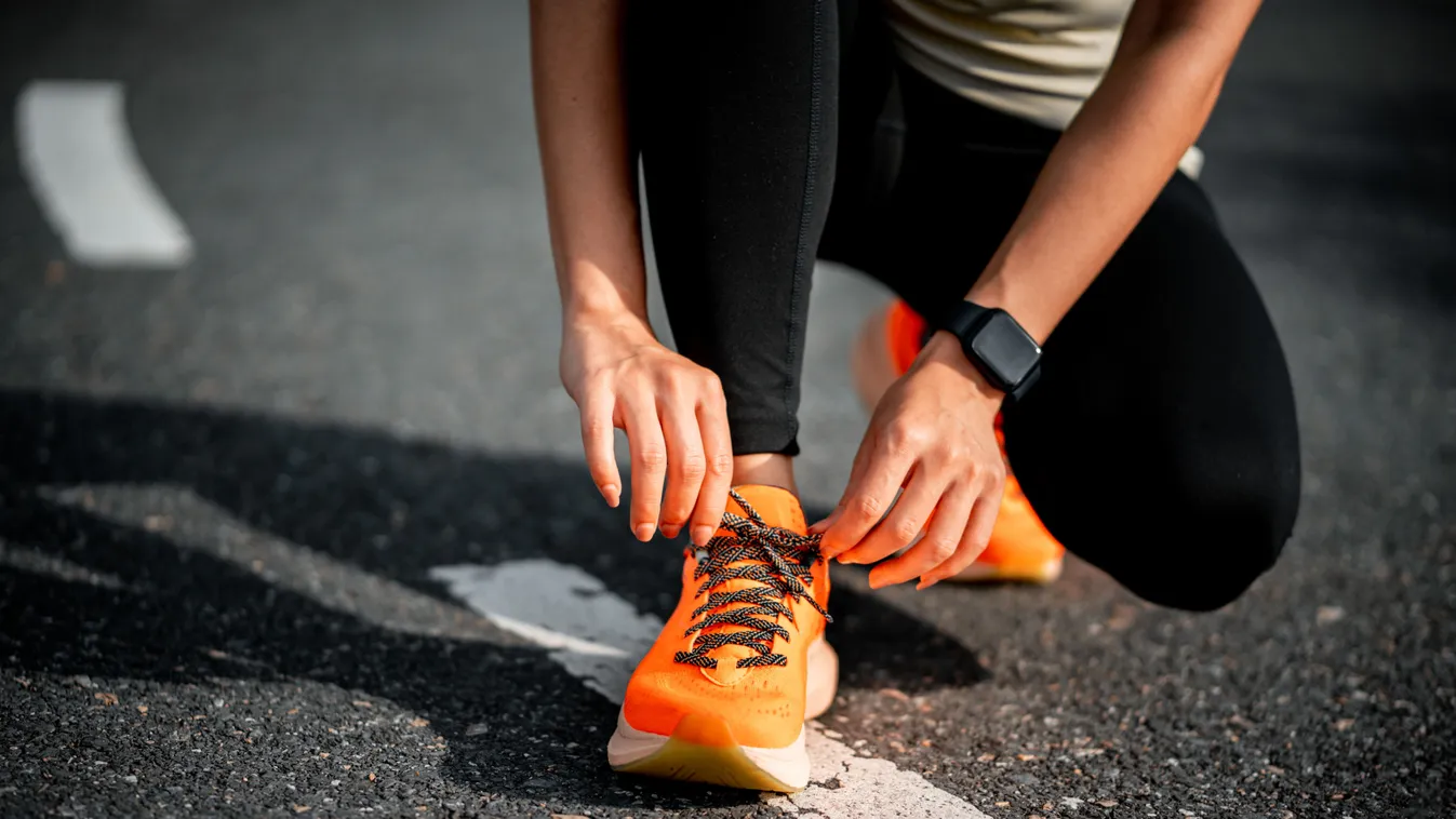 Running shoes. Woman tying shoe laces. Closeup of female sport fitness runner getting ready for jogging outdoors on forest path in late summer or fall. Jogging girl exercise motivation heatlh and fitness.