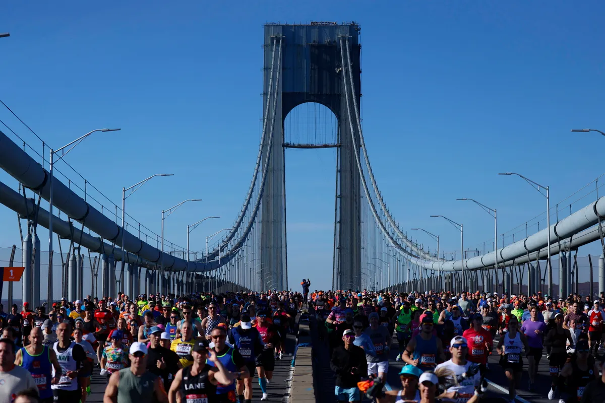 Runners cross over the span of Verrazzano Narrows Bridge when they compete in the 2024 NYRR TCS New York City Marathon i